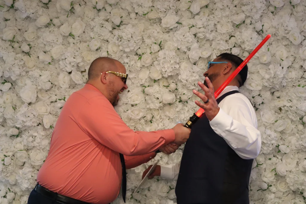 Guests sharing a joyful photo booth moment at a beÜtiful Pixels event