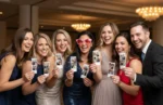 Group of guests holding matching photo booth prints at an elegant event, showing the fun of unlimited prints from beÜtiful Pixels.