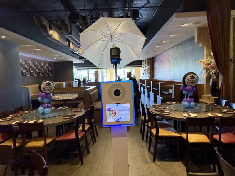 Self-serve digital photo booth setup at a celebration venue with tables and decor, representing the Keep It Simple package from beÜtiful Pixels.