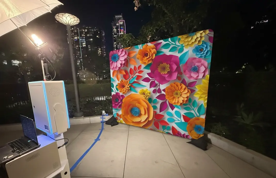 Event guests enjoying a photo booth session with props in front of a gold sequin backdrop, representing a flexible backdrop option for many celebrations.