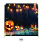 Halloween photo booth backdrop with glowing jack-o’-lanterns, string lights, candles, and rustic wood background.