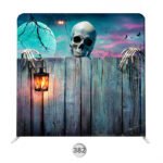 Halloween photo booth backdrop with skull, skeletal hands, glowing lantern, wood fence, bats, and moonlit night sky.