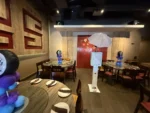 Modern digital photo booth with blue LED edge glow and interactive screen, photographed inside an event space.