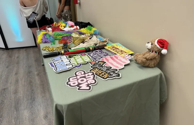 Birthday-themed photo booth props including "Birthday Queen" and "Make a Wish" signs displayed on a table for an Anaheim party.